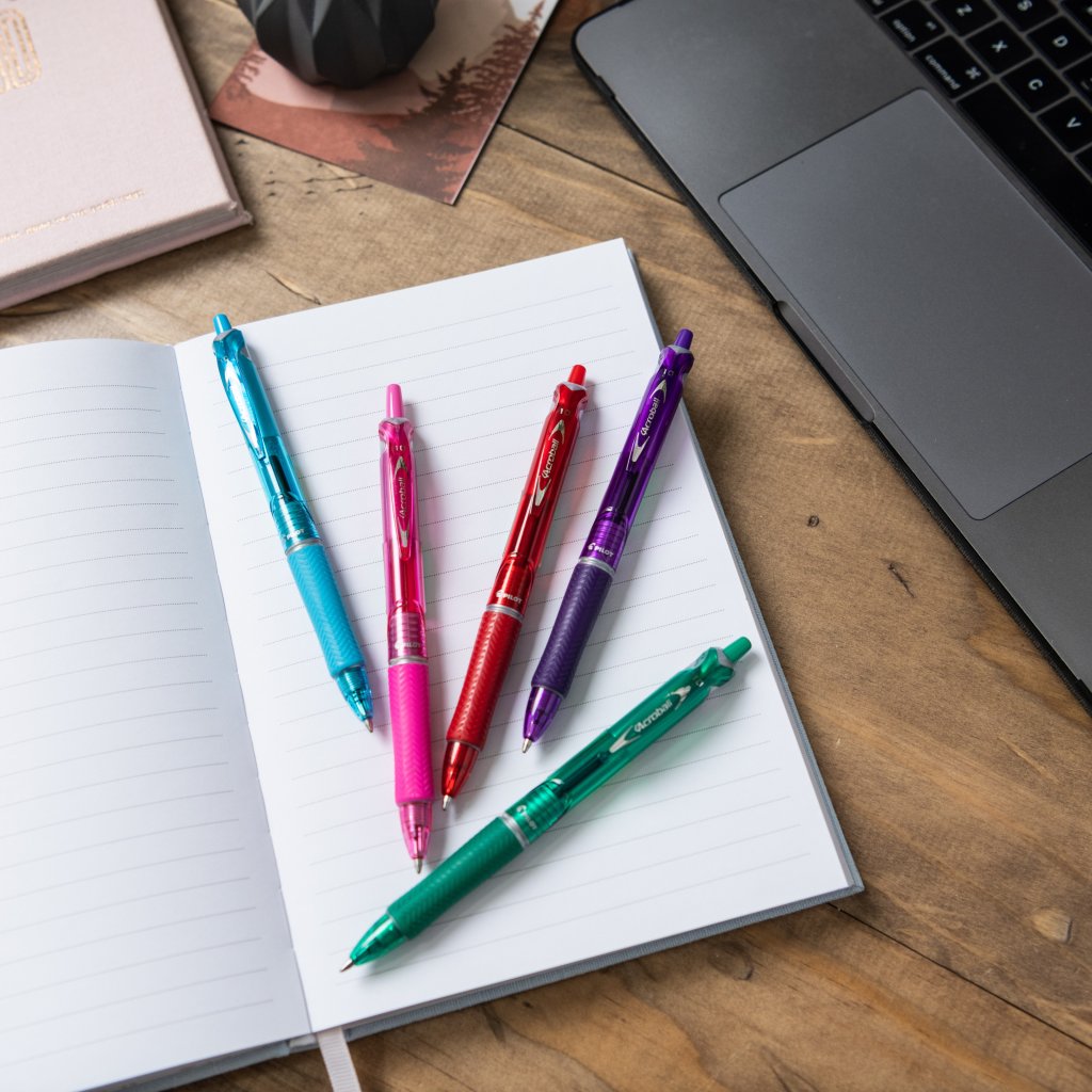 BegreeN Acroball Retractable Ballpoint Pens by Pilot Pen in blue, pint, red, purple and green on a note pad on a desk.